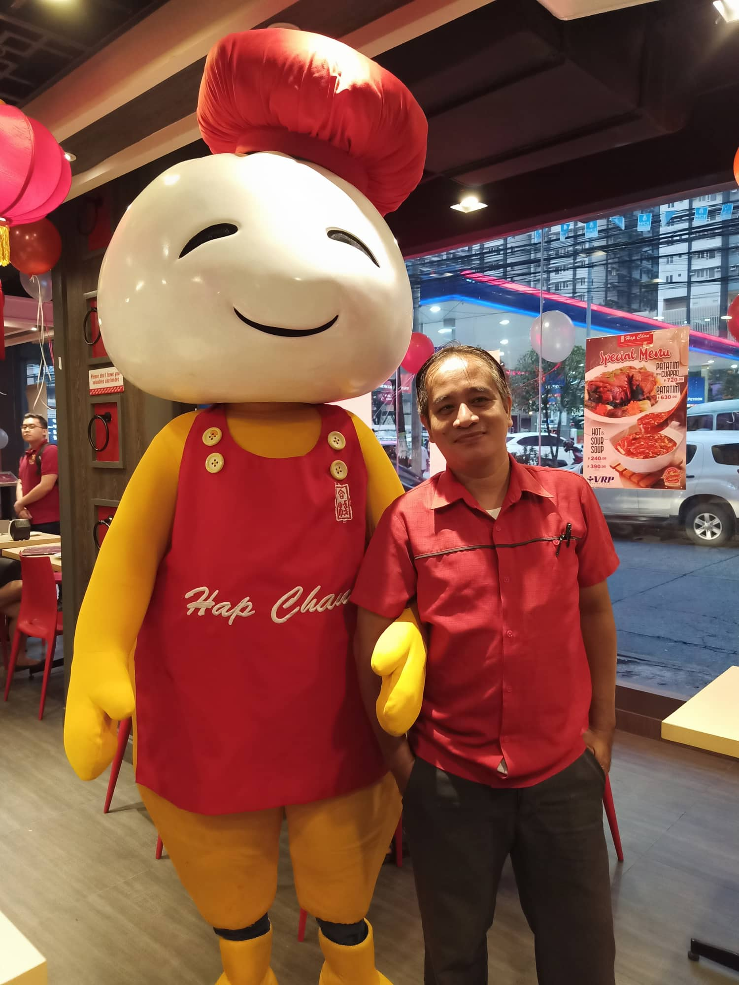 man smiling with hap chan mascot