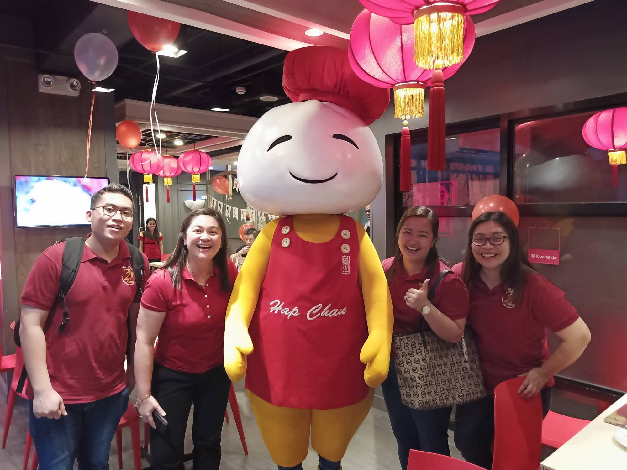 group of hap chan staff smiling with hap chan mascot